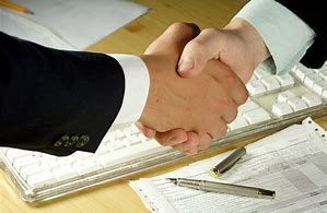 Professional handshake over architectural blueprints